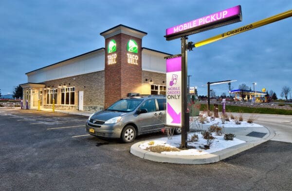 Taco Bell mobile pickup area, with a car parked for order collection at a restaurant.