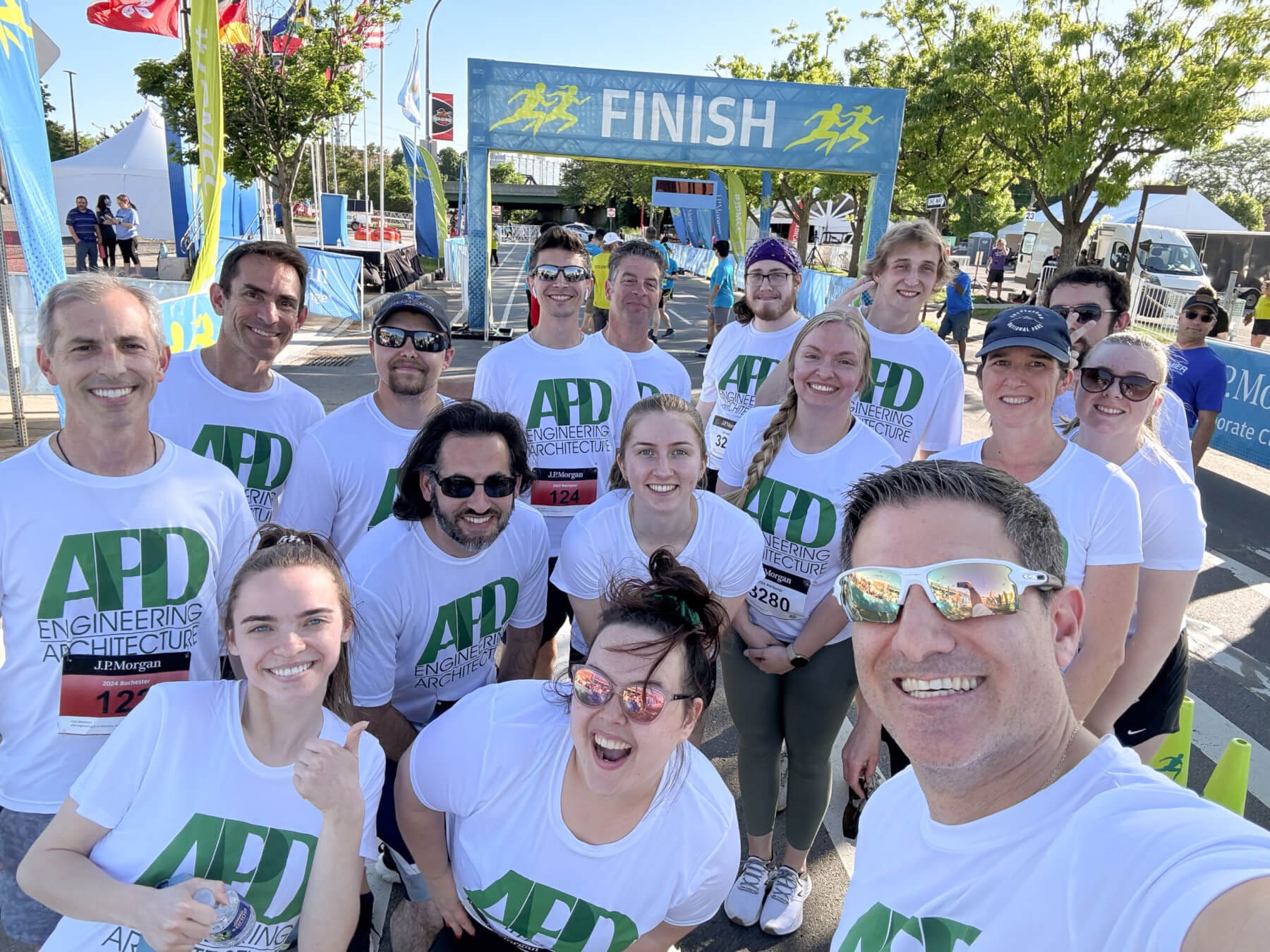 Team of APD Engineering celebrates at the finish line of a charity race event.