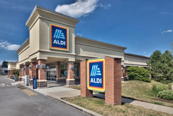 Exterior view of an ALDI supermarket with branded signage on a sunny day.