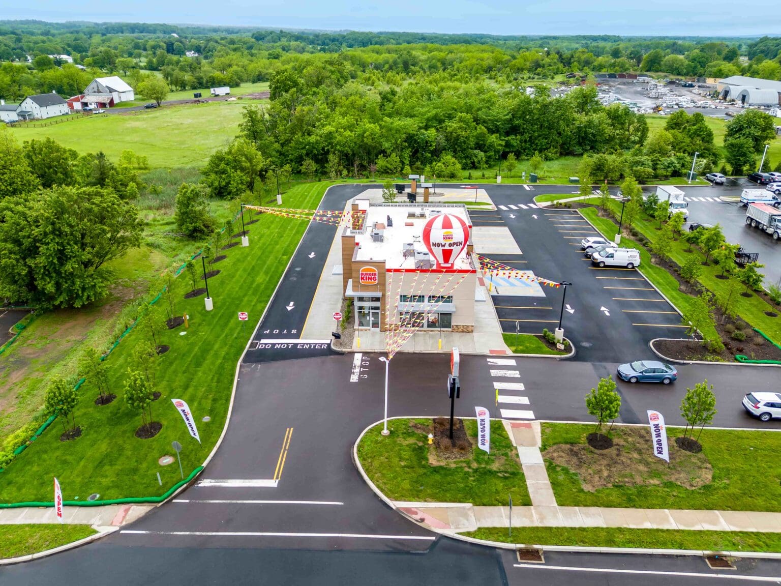 Aerial view of new Burger King location surrounded by green fields, highlighting the grand opening.