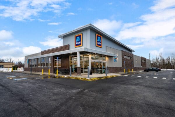 Modern Aldi supermarket exterior with parking lot on a clear day.