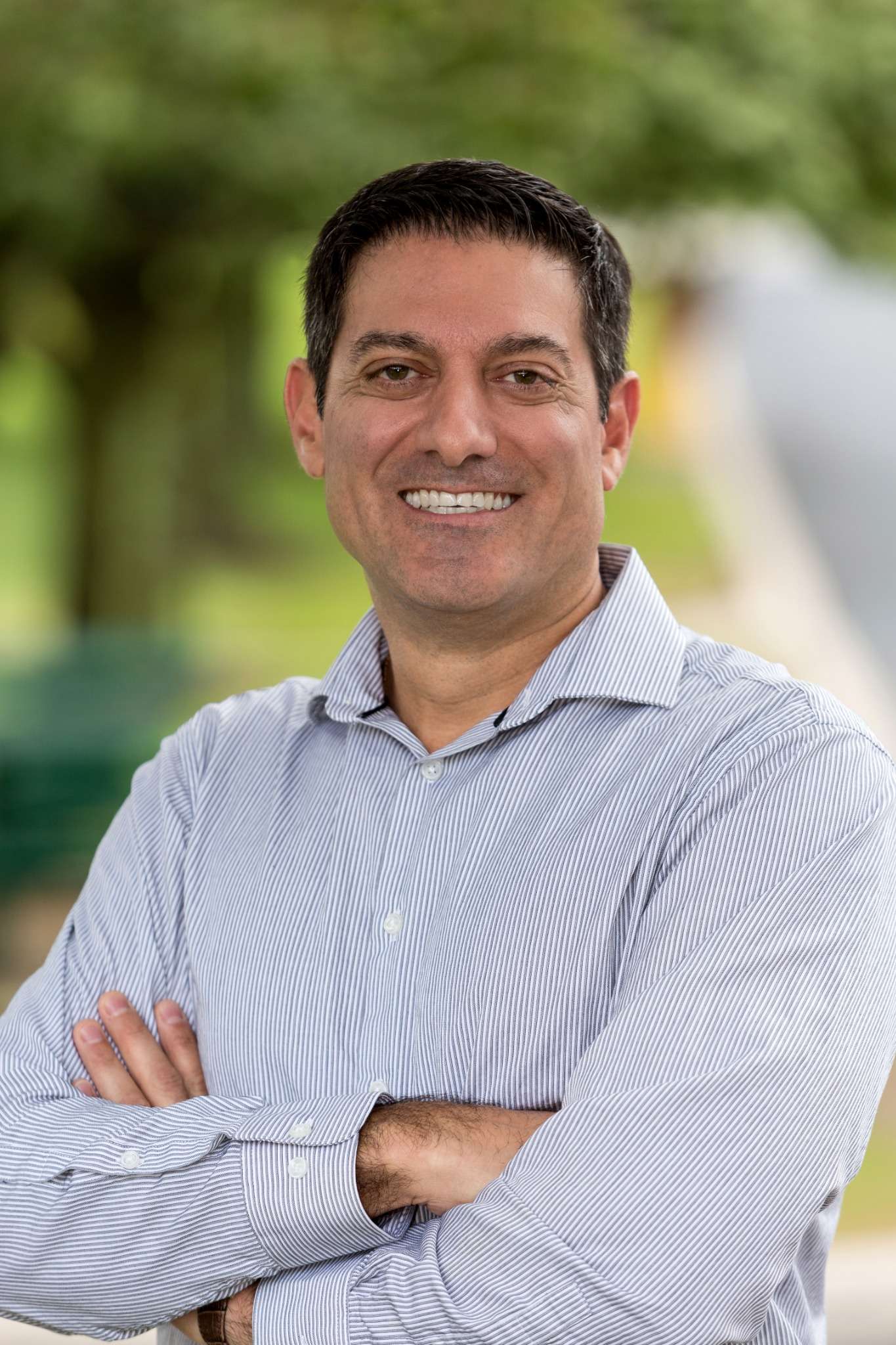 Business professional smiling in outdoor setting.