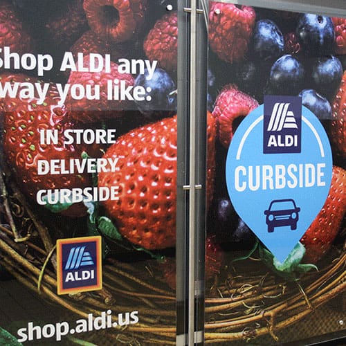 Aldi offers shopping options: in-store, delivery, curbside. Fresh produce background. Visit shop.aldi.us.