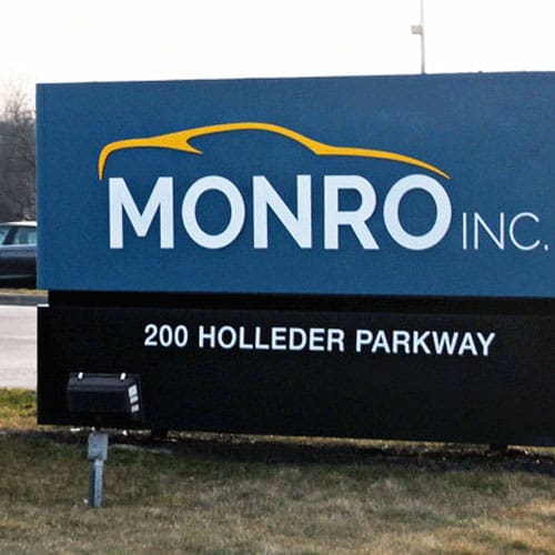 Monro Inc. sign at 200 Holleder Parkway, featuring a yellow car outline.