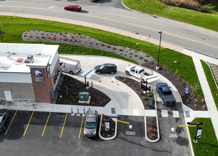 Taco Bell drive-thru with cars waiting in line on a sunny day, showcasing efficient service and easy access.