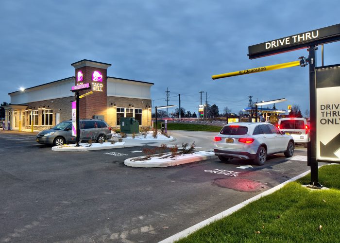 Taco Bell drive-thru with cars in line at dusk, highlighting convenience for fast-food lovers.