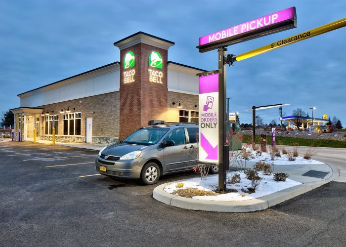 Taco Bell mobile pickup area, with a car parked for order collection at a restaurant.