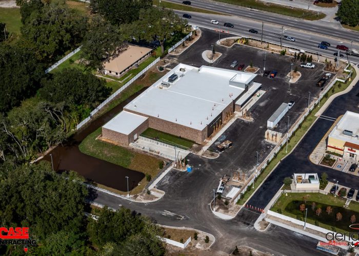 Aerial view of commercial construction site by Case Contracting, showcasing building progress and surrounding landscape.