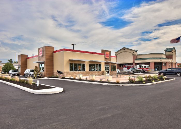 Modern Burger King restaurant exterior with parking lot under a clear sky.
