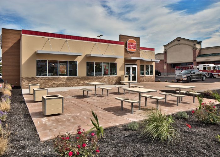 Burger King restaurant exterior with outdoor seating area and landscaped garden.
