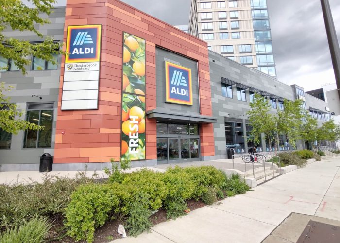 Exterior view of ALDI store entrance with fresh produce signage.