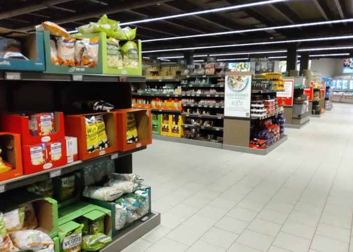 Grocery aisle with a variety of snacks and beverages on shelves, highlighting a well-stocked supermarket.