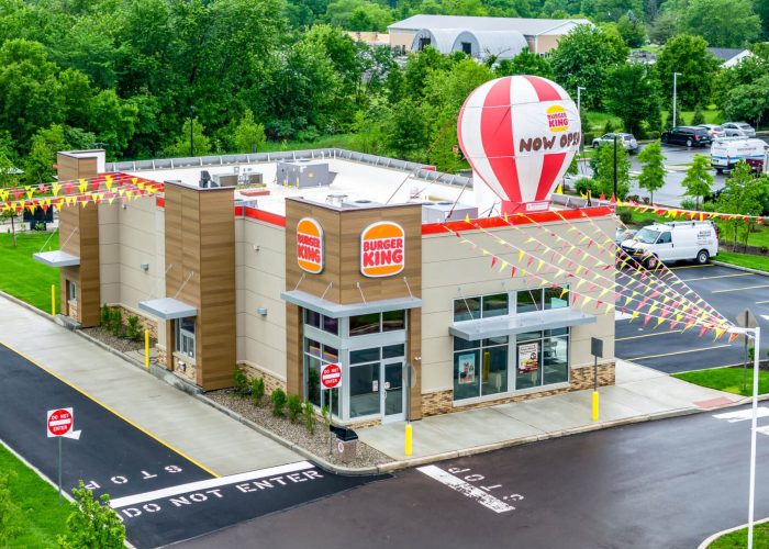 Burger King grand opening with festive balloon and banners. Fresh fast food now available.
