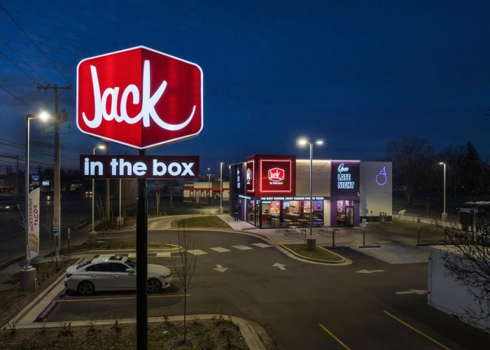 Jack in the Box restaurant at night with illuminated sign, showcasing its vibrant brand and night-time service.