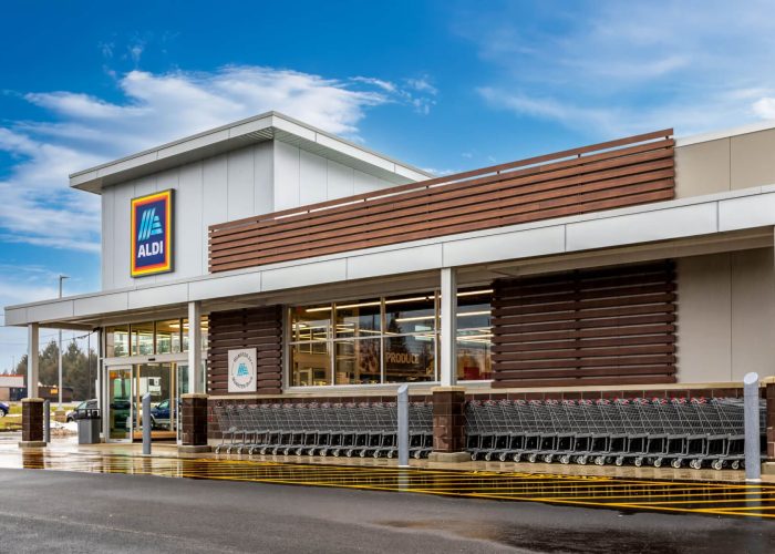 Exterior view of an ALDI store with shopping carts, showcasing modern architecture and inviting shopping atmosphere.