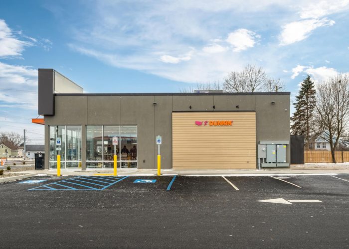 Exterior of a Dunkin' location with accessible parking on a clear day, perfect for coffee lovers.