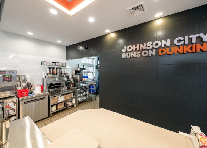 Dunkin' kitchen area in Johnson City with brewing equipment and branded wall sign.