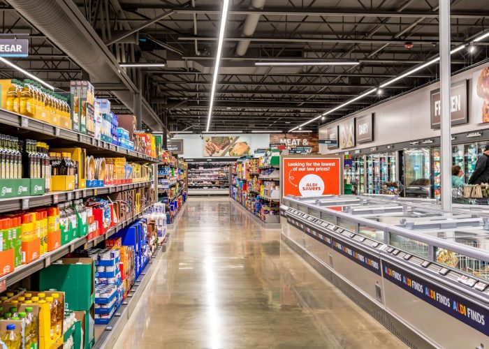 Aldi grocery aisle featuring product variety and low-price signage, highlighting the Aldi Savers program.