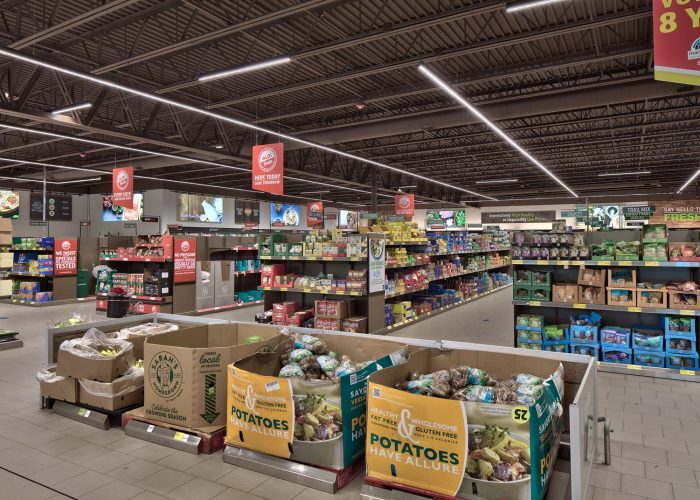 Grocery aisle with fresh produce and discount signage at an Aldi store.