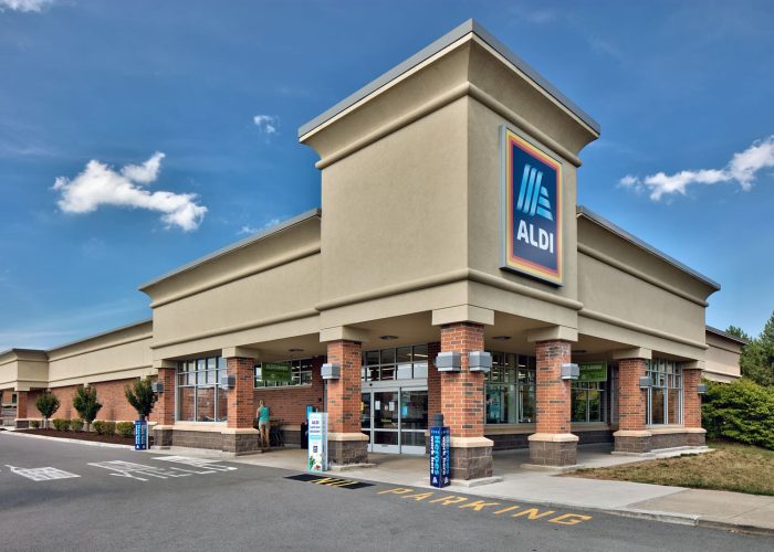 Modern Aldi store exterior on a clear day, highlighting parking area and entrance.