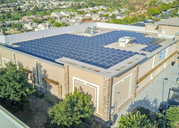 Rooftop solar panels on commercial building, showcasing renewable energy solutions in the community.