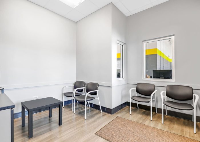 Modern waiting room with chairs and a small table, designed for comfort at [Brand Name] auto shop.