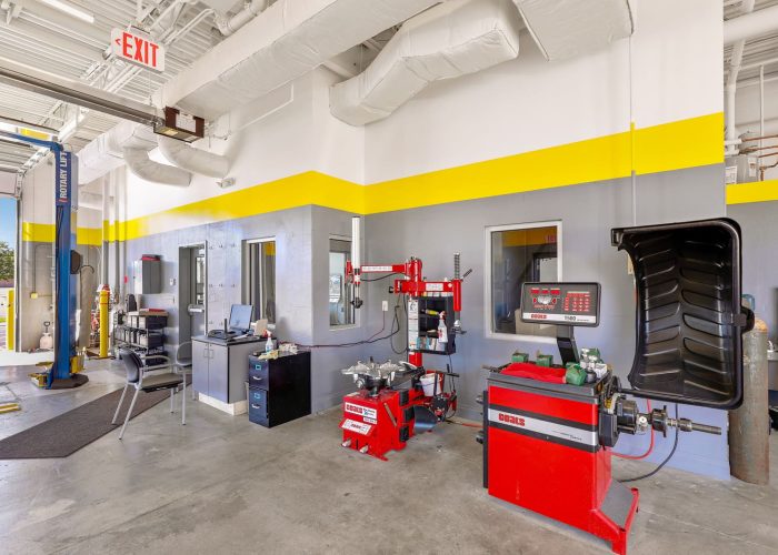 Auto shop interior with tire changing equipment and workstation, showcasing modern repair tools.