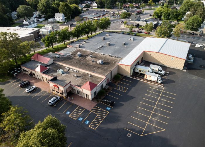 Aerial view of a spacious warehouse parking lot with delivery trucks, highlighting logistics capabilities.