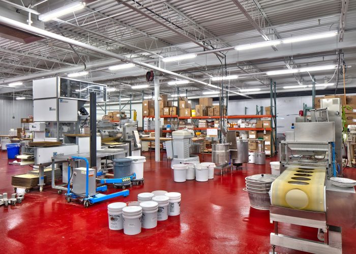 Modern factory interior with machinery and storage, showcasing efficient manufacturing processes.