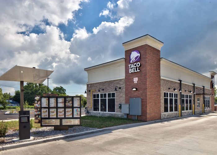 Taco Bell drive-thru with menu board, sunny day. Enjoy fast food favorites.