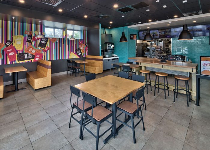 Modern fast-food restaurant interior with colorful decor and seating options, emphasizing a casual dining experience.