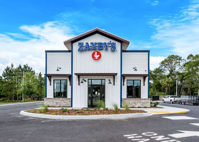 Storefront of Zaxby's with clear blue sky, emphasizing the fast-food brand's welcoming exterior.